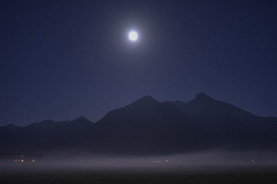 Scenic view of illuminated mountains against sky at night