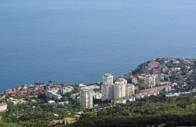 High angle view of townscape by sea against sky