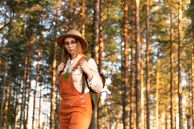 Woman botanist with backpack on ecological hiking trail. naturalist exploring wildlife ecotourism.