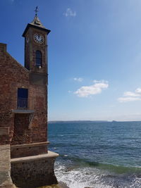 Scenic view of sea by building against sky