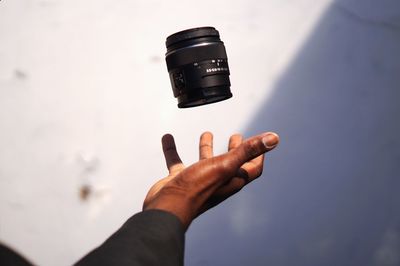 Close-up of hand throwing camera lens