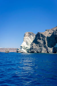 Face shaped rock on the blue sea against a blue sky. at akrotiri, santorini, cyclades, greece