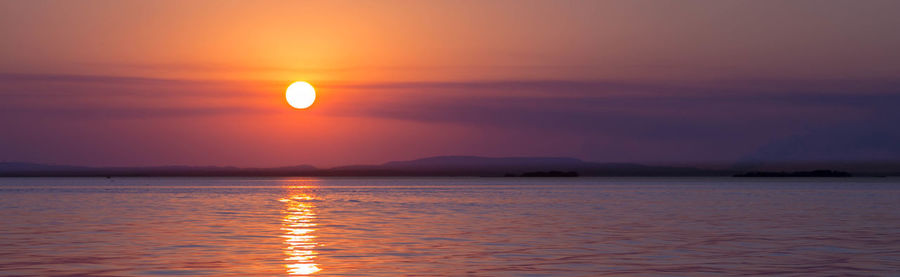 Scenic view of sea against romantic sky at sunset