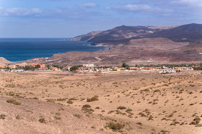 Scenic view of sea and mountains against sky