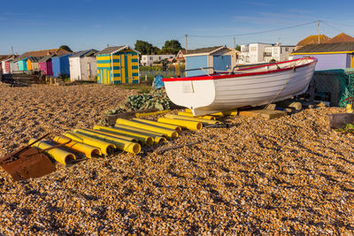 Lounge chairs on beach by buildings against sky