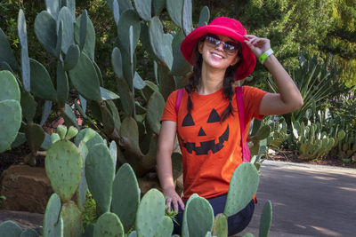 Portrait of smiling woman standing against plants