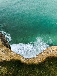 High angle view of sea splashing against rock formation