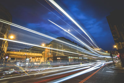 Light trails on city street against sky at night