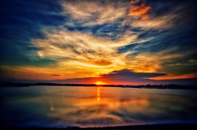 Scenic view of sea against dramatic sky during sunset