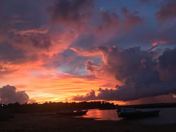 Scenic view of sea against dramatic sky during sunset