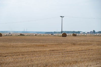 Hay bales on field against sky