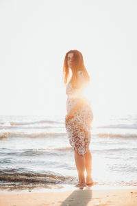 Full length of woman standing at beach