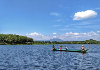 People in lake against sky