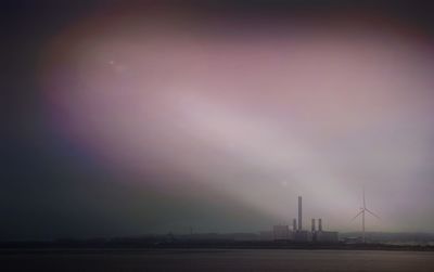 Industrial building against cloudy sky