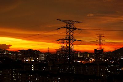 Silhouette electricity pylon against sky at night