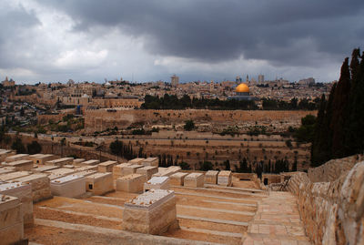 Buildings in city against cloudy sky