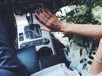 Midsection of woman showing wedding ring in car