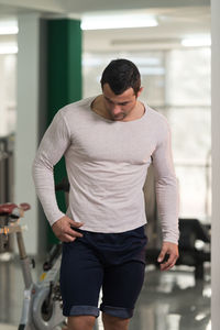 Muscular man standing in gym