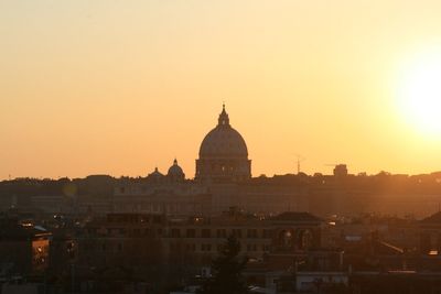 View of buildings in city against clear sky during sunset