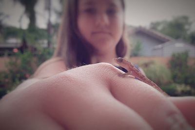 Close-up of woman holding lizard