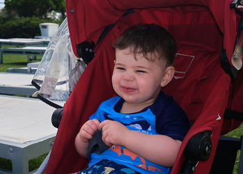 Young boy sitting in his stroller by the pool at the resort