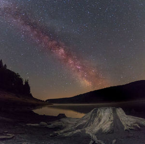 Scenic view of lake against sky at night