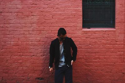 Man standing on brick wall