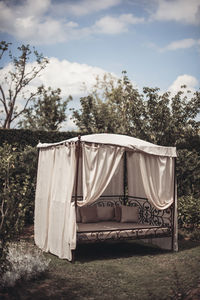 Clothes drying on field by trees against sky