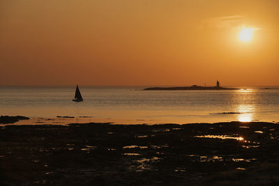 Scenic view of sea against orange sky