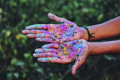 Close-up of hands covered in colorful paint