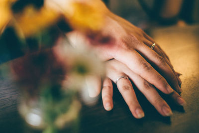Cropped hand of man holding woman hand on table