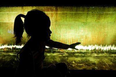 Side view of girl playing at night