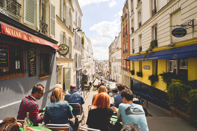 People sitting on street in city