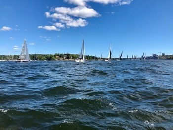 Sailboats sailing in sea against sky