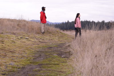 Rear view of people walking on field