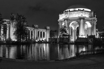 Reflection of illuminated building in water at night