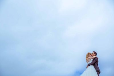 Low angle view of woman standing against sky