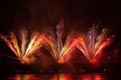 Firework display over river at night