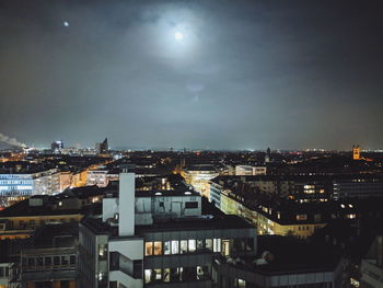 High angle view of illuminated buildings against sky at night