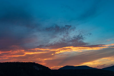 Scenic view of silhouette mountains against sky during sunset