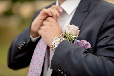 Midsection of bridegroom holding hands