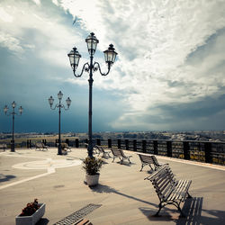 Street light by sea against sky