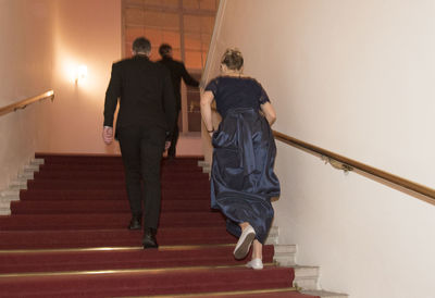 Rear view of people walking on staircase