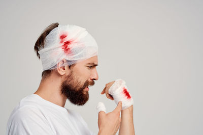 Young man wearing bandages on injuries