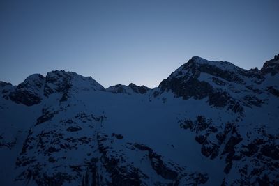 Scenic view of snowcapped mountains against clear sky