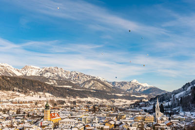 Aerial view of townscape and mountains against sky