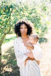 Portrait of young woman standing on field