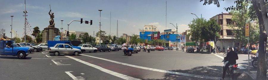 Panoramic shot of cars on city street against sky