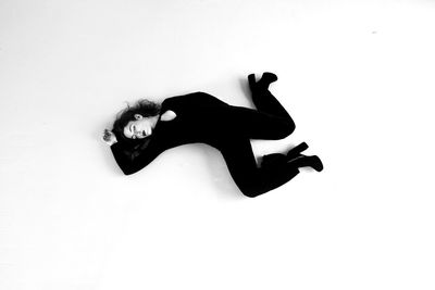 High angle view of woman lying on white background