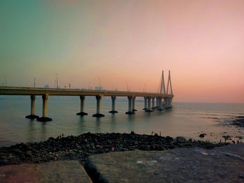 Pier over sea against sky during sunset